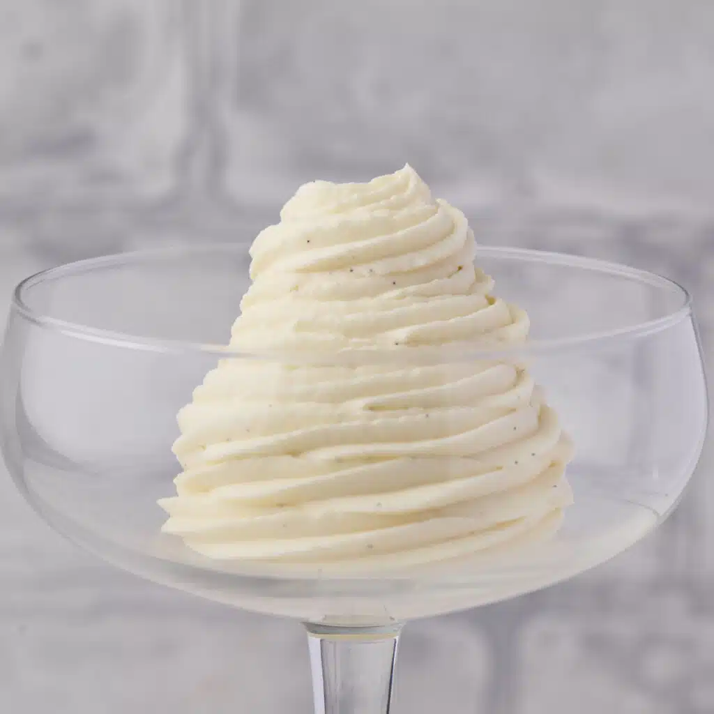 Chantilly cream piped in a swirl inside a coupe glass.