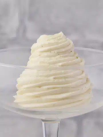 Chantilly cream piped in a swirl inside a coupe glass.