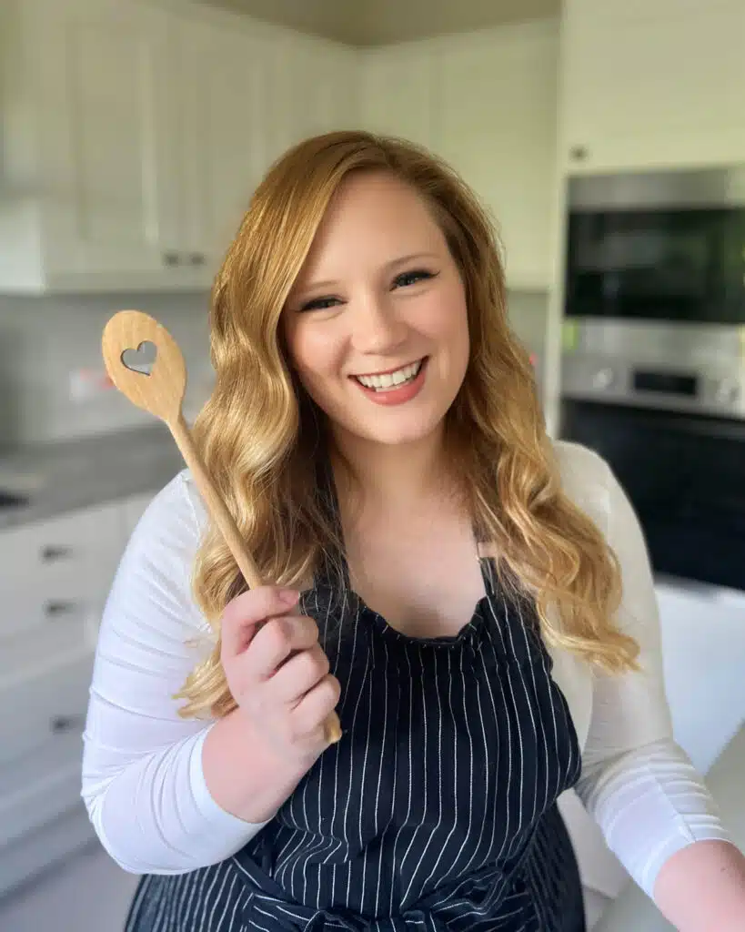 Jules (Juliane) Grasekamp, baking blogger at Bonni Bakery standing in the kitchen holding a heart spoon.