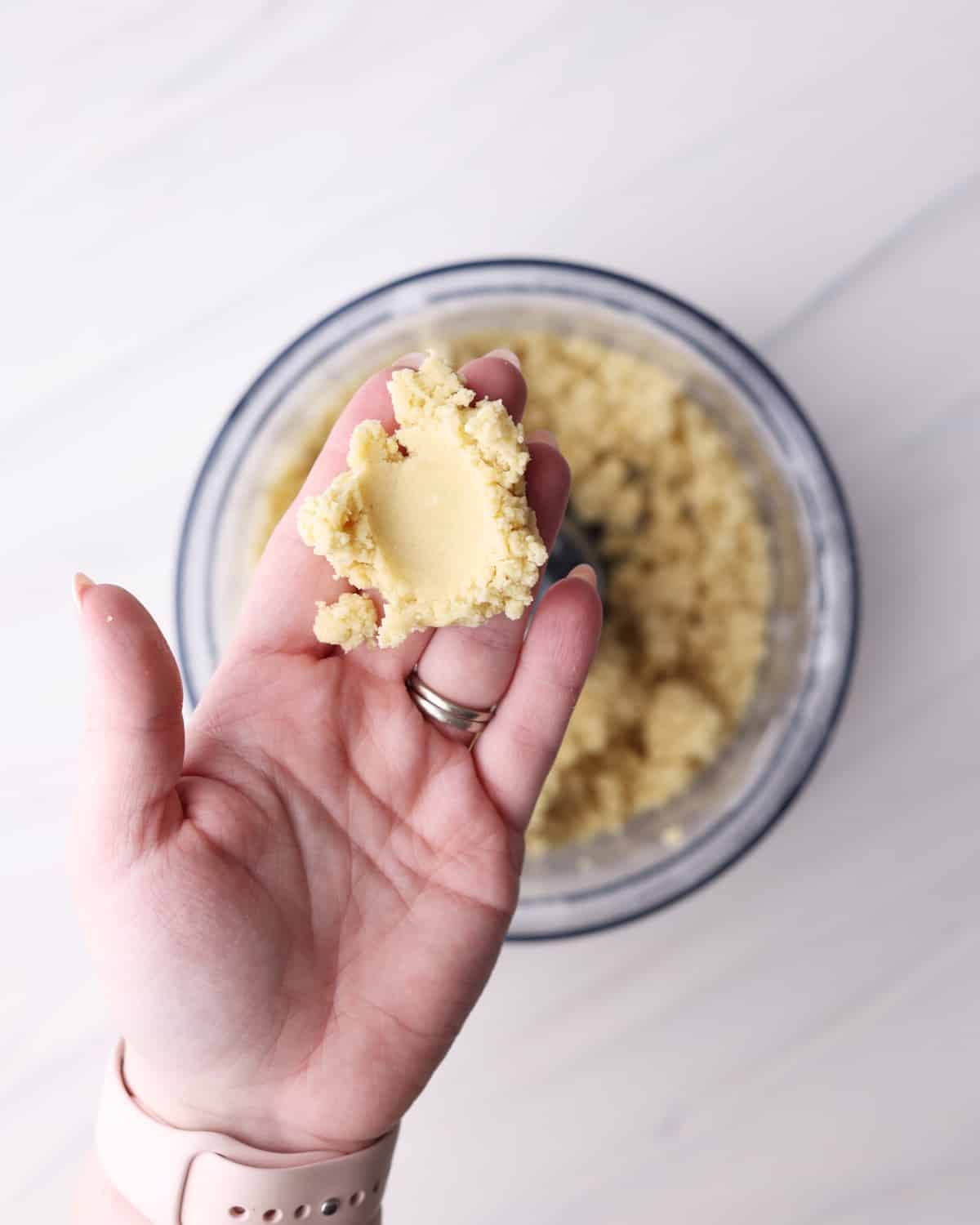 Checking shortcrust pastry to see if it is ready by squeezing the pastry together.