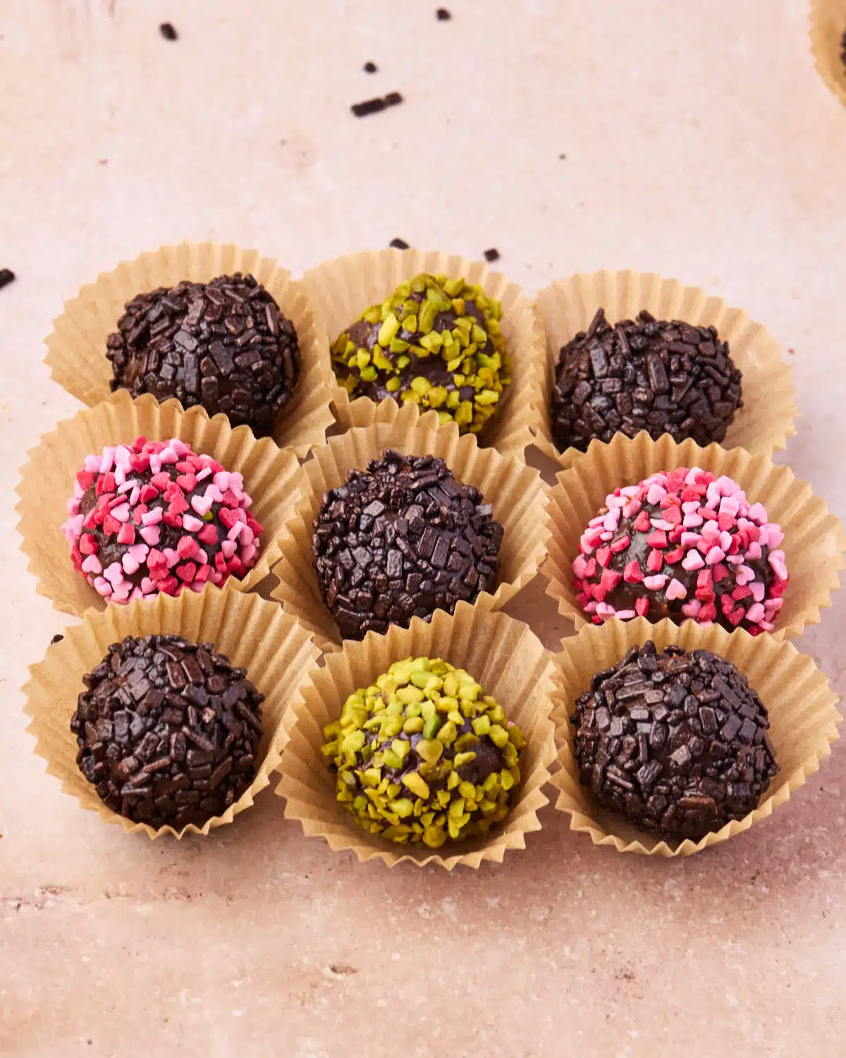 9 brigadeiro lined up in a square, all with different toppings.