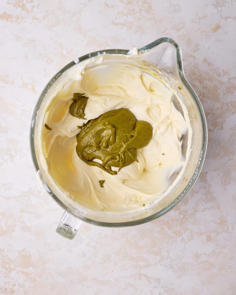 Adding pistachio paste to cheesecake batter to make pistachio cheesecake. 