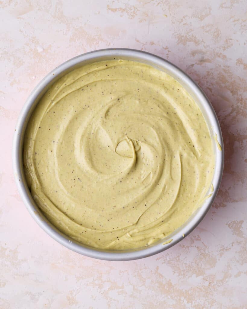 Pistachio cheesecake batter in a cheesecake pan, ready to be baked. 