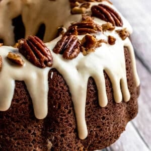 cream cheese glaze dripping down a pecan bundt cake.