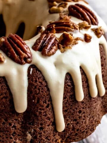 cream cheese glaze dripping down a pecan bundt cake.