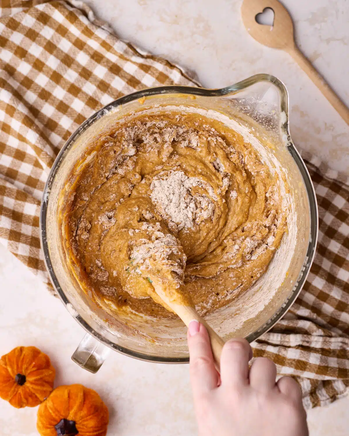 Slowly mixing flour into pumpkin cake batter.
