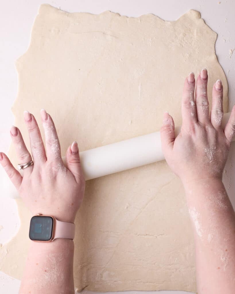 Rolling out puff pastry with a rolling pin.