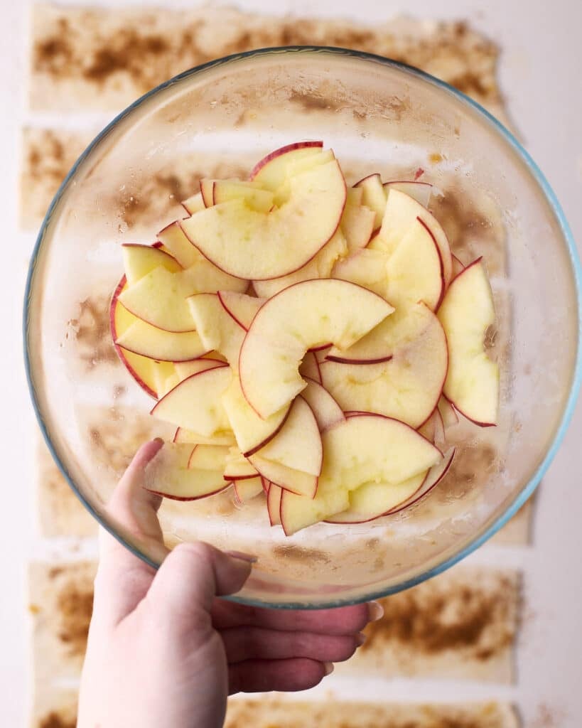 Bowl of sliced apples that have just been microwaved to make them softer to roll into apple roses.