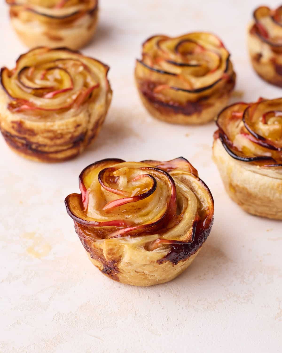 Baked puff pastry apple roses sitting on a table.