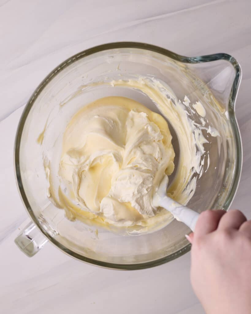 Folding whipped cream into pastry cream to make the filling for Bavarian cream donuts. 