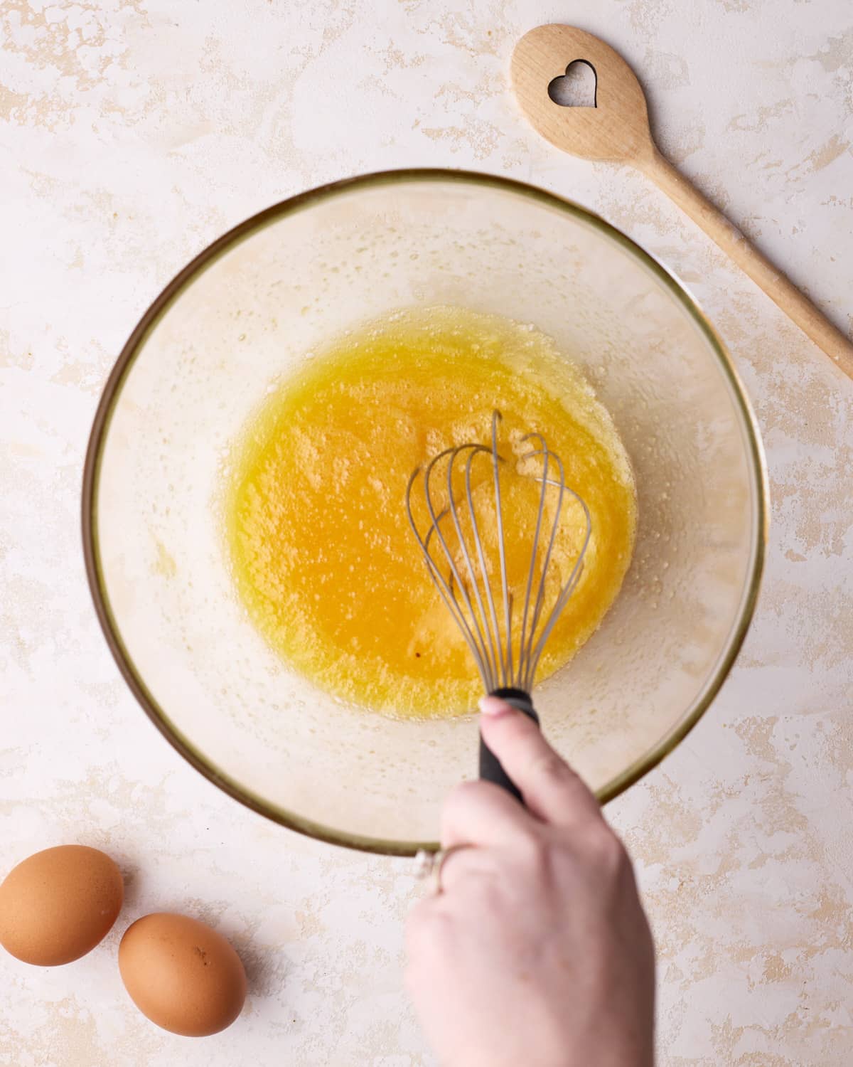 Whisking eggs and sugar together to make custard pie.