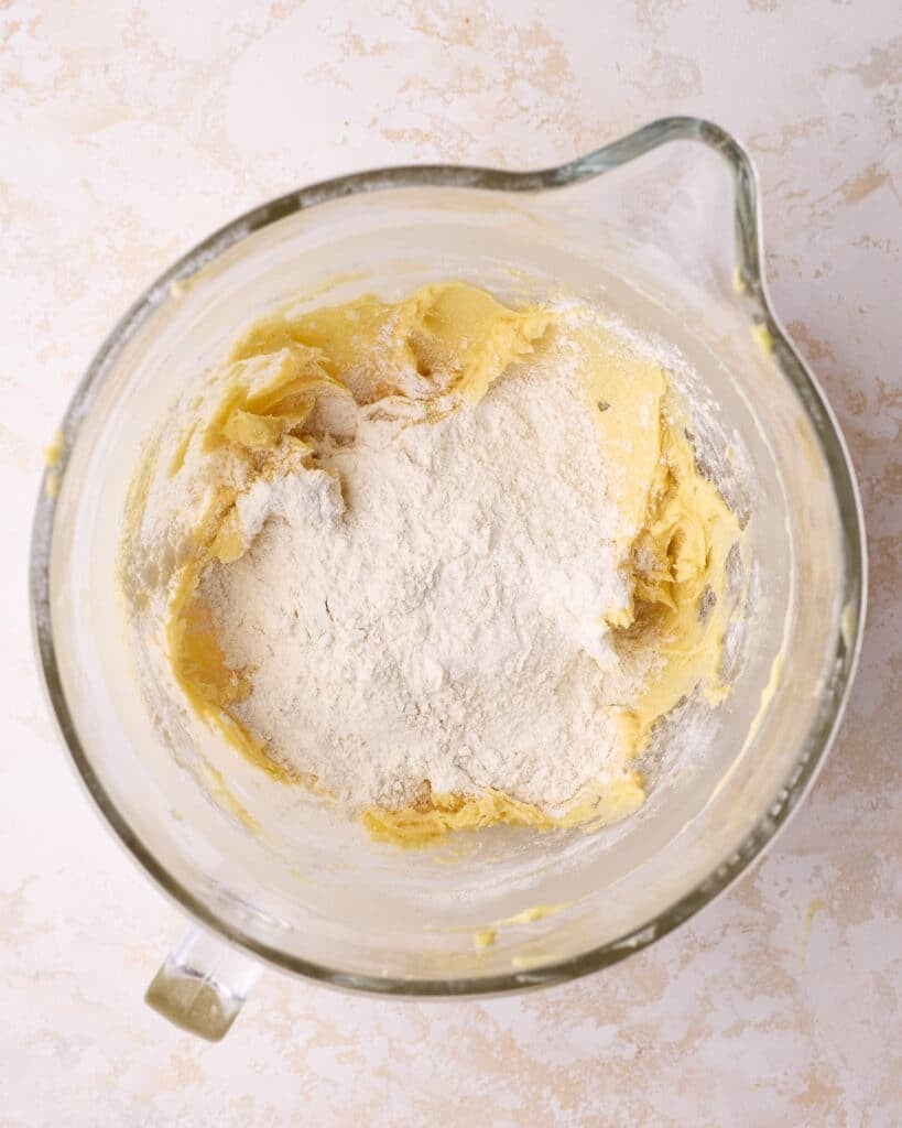 Process shot showing flour being added to the bowl to make Danish butter cookies.