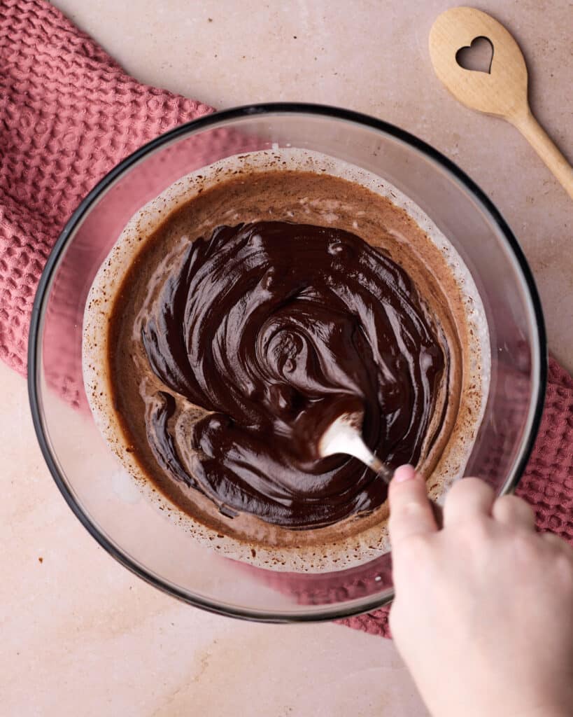 Mixing chocolate and cream together to make chocolate ganache for a chocolate mousse pie. 