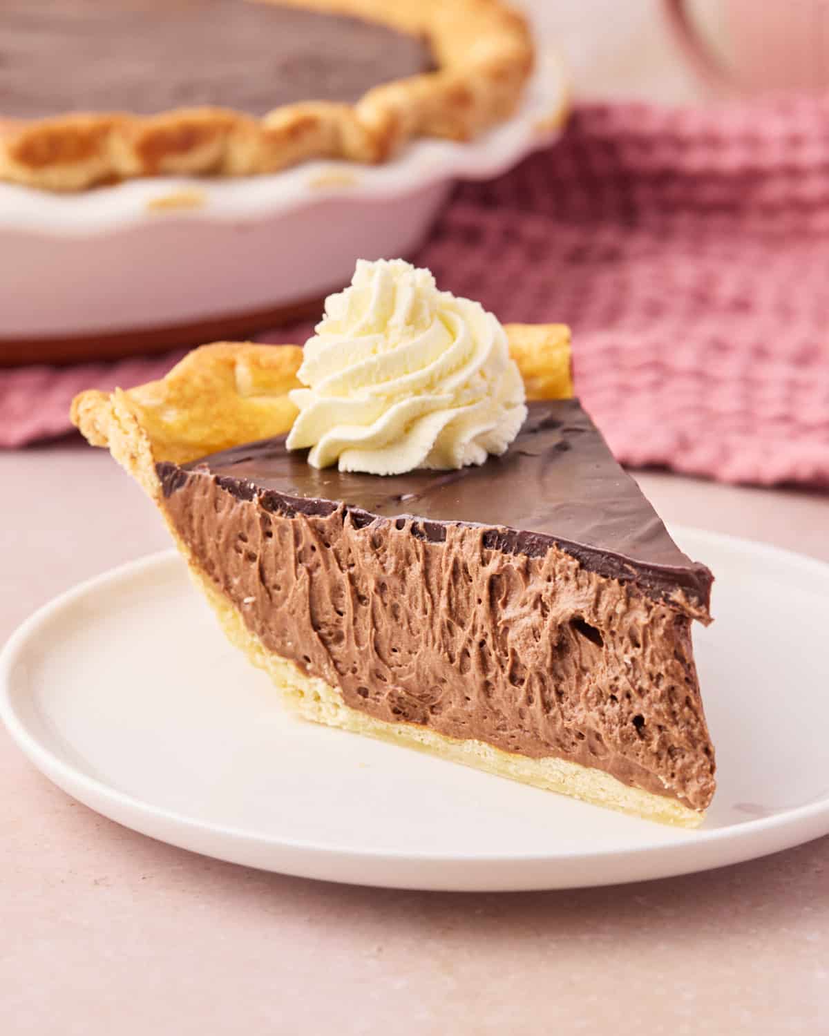 Slice of chocolate mousse pie from the side to show the silky smooth filling.