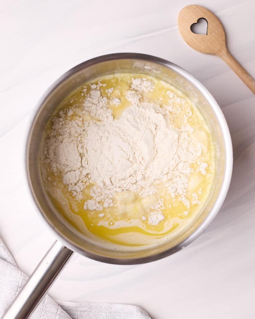 Adding flour to hot liquids in a saucepan to make a panade for choux pastry. 