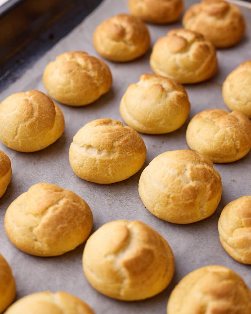 Baked profiteroles fresh out of the oven, round and puffed up. 