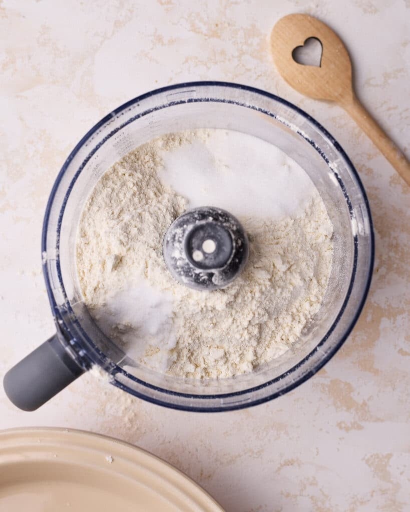 Adding flour, salt and sugar to a food processor to make easy pie dough. 