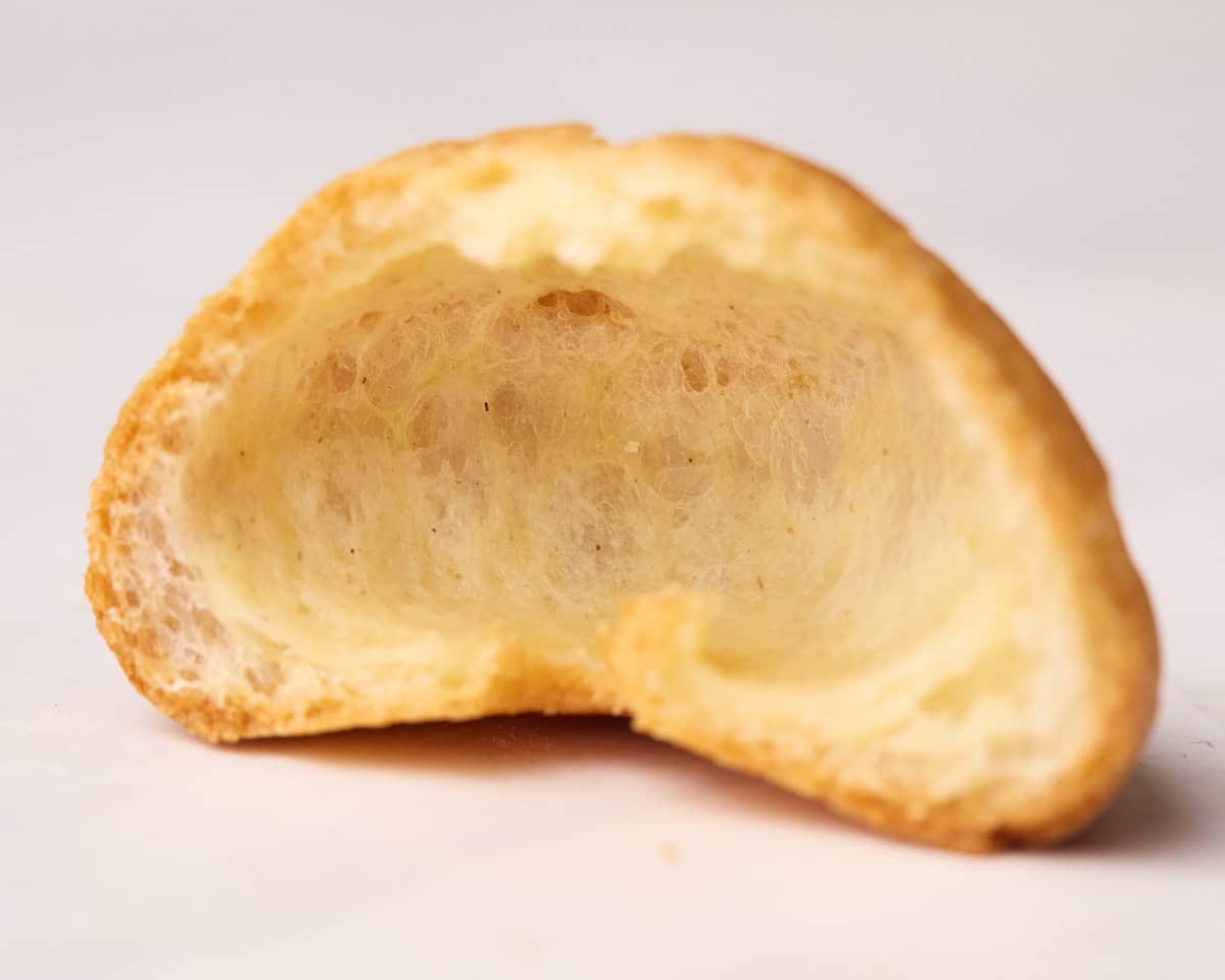 An empty profiterole cut in half to show how it should look with a hollow center. 