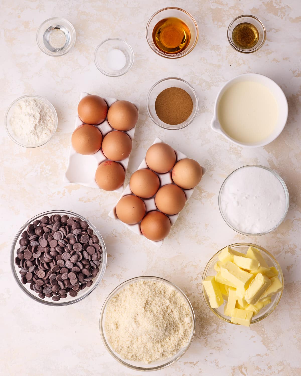 Ingredients to make classic French Opera cake - eggs, almond flour, butter, sugar, heavy cream, dark chocolate, espresso powder, cake flour. 