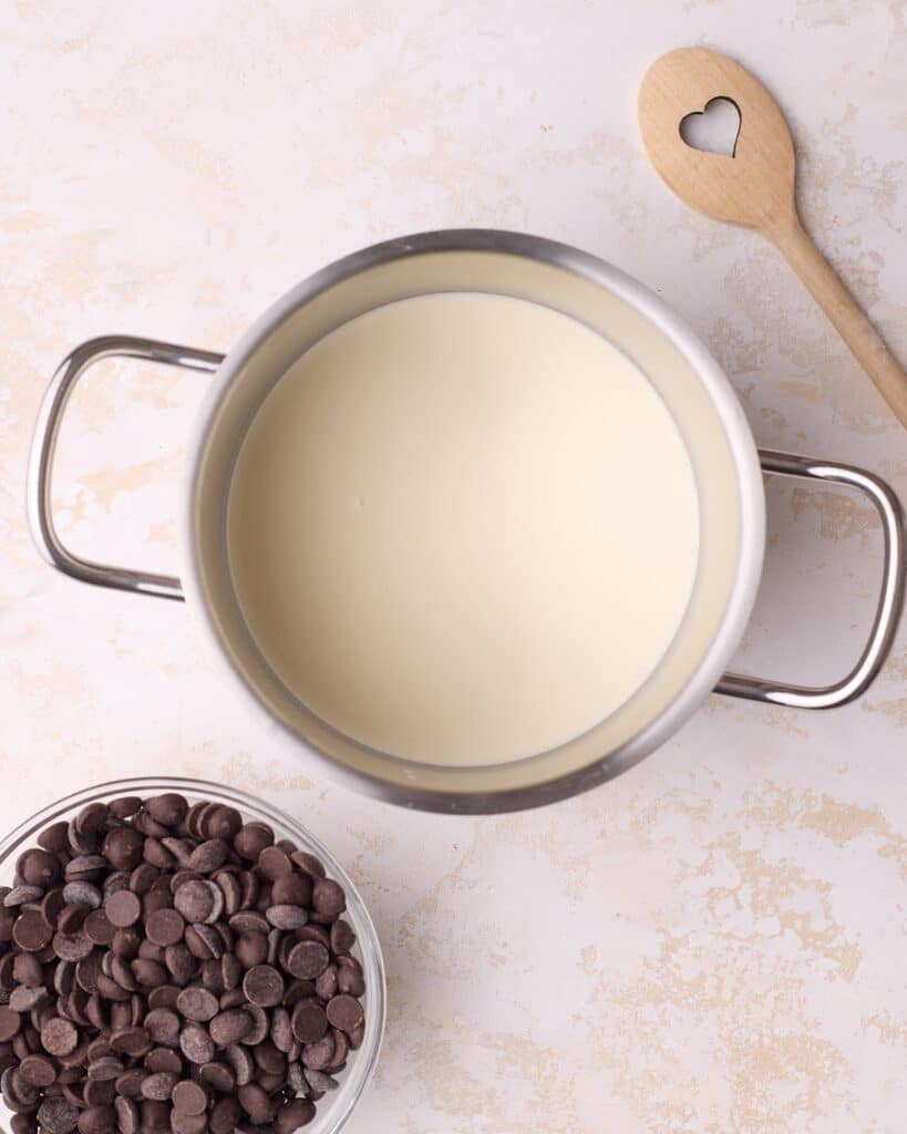 Heating heavy cream in a saucepan to make chocolate ganache.