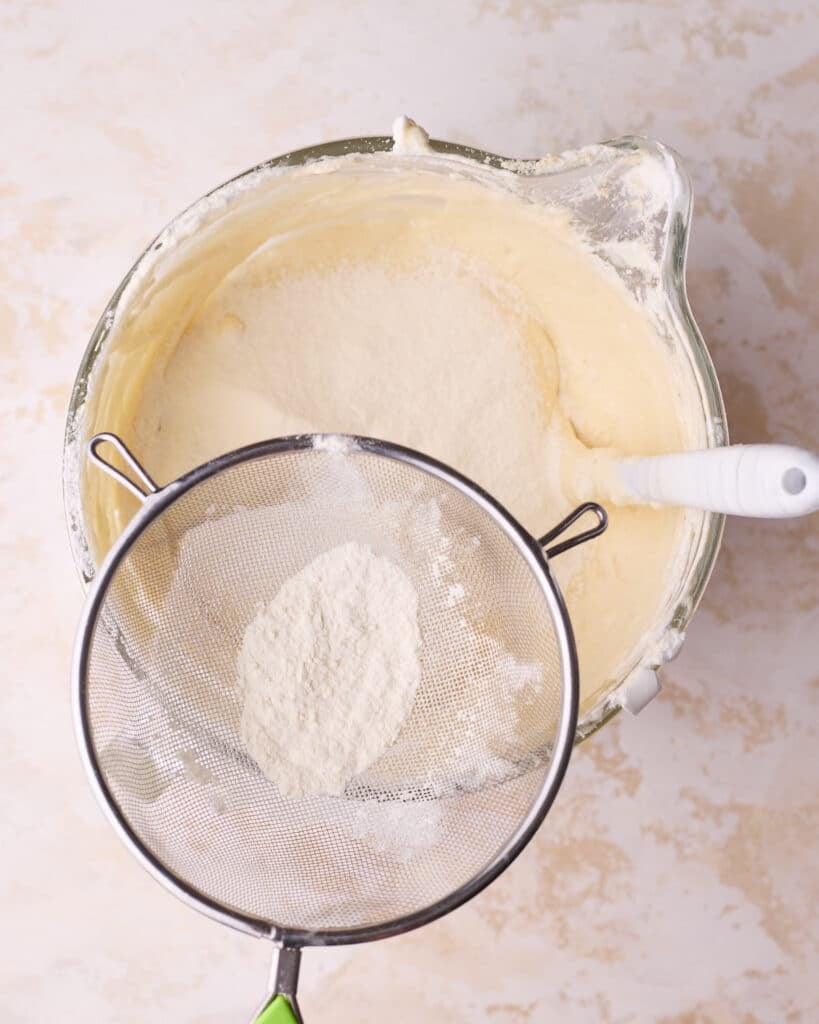 Sifting flour on top of joconde sponge mixture. 