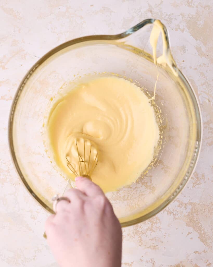 Whipped egg yolks in a large glass stand mixer bowl, they have gone pale and thick. 