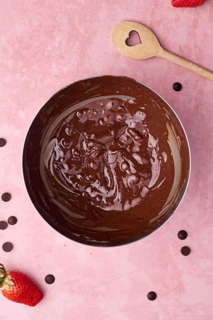 Melting chocolate in a heatproof bowl to temper the chocolate for chocolate covered strawberries. 