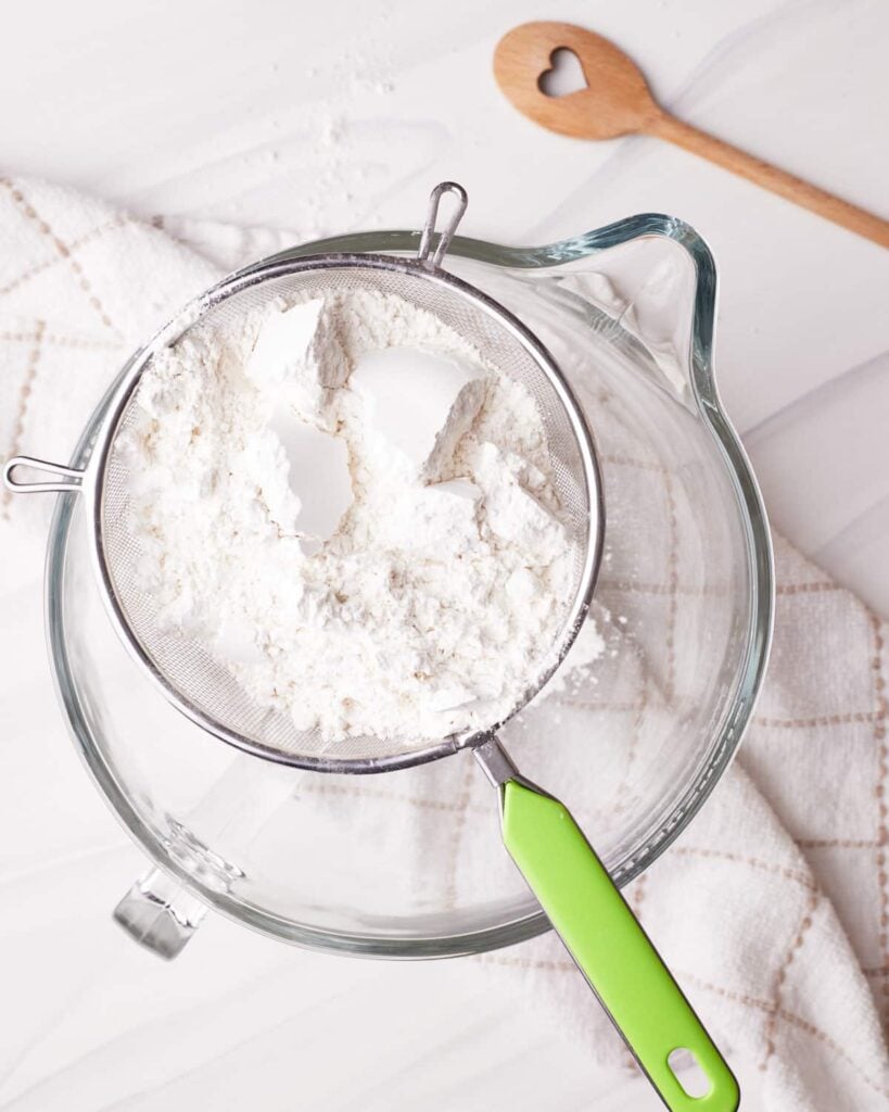 Dry ingredients being sifted into a bowl.