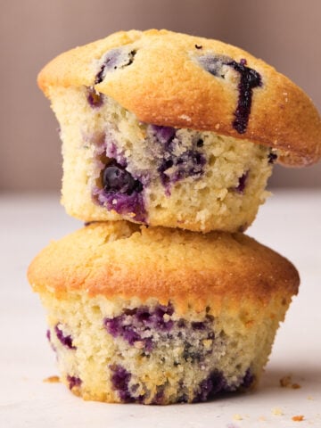 Two blueberry muffins stacked on top of one another.