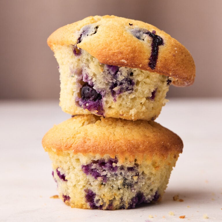 Two blueberry muffins stacked on top of one another.