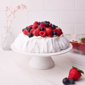 Finished pavlova sitting on a cake stand.