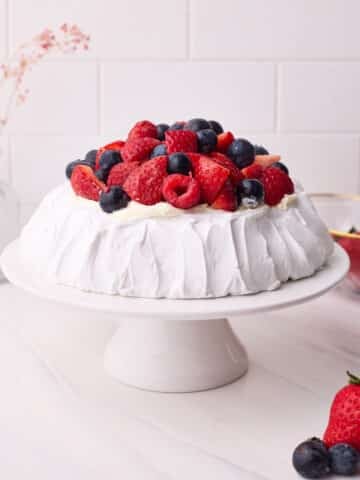 Finished pavlova sitting on a cake stand.