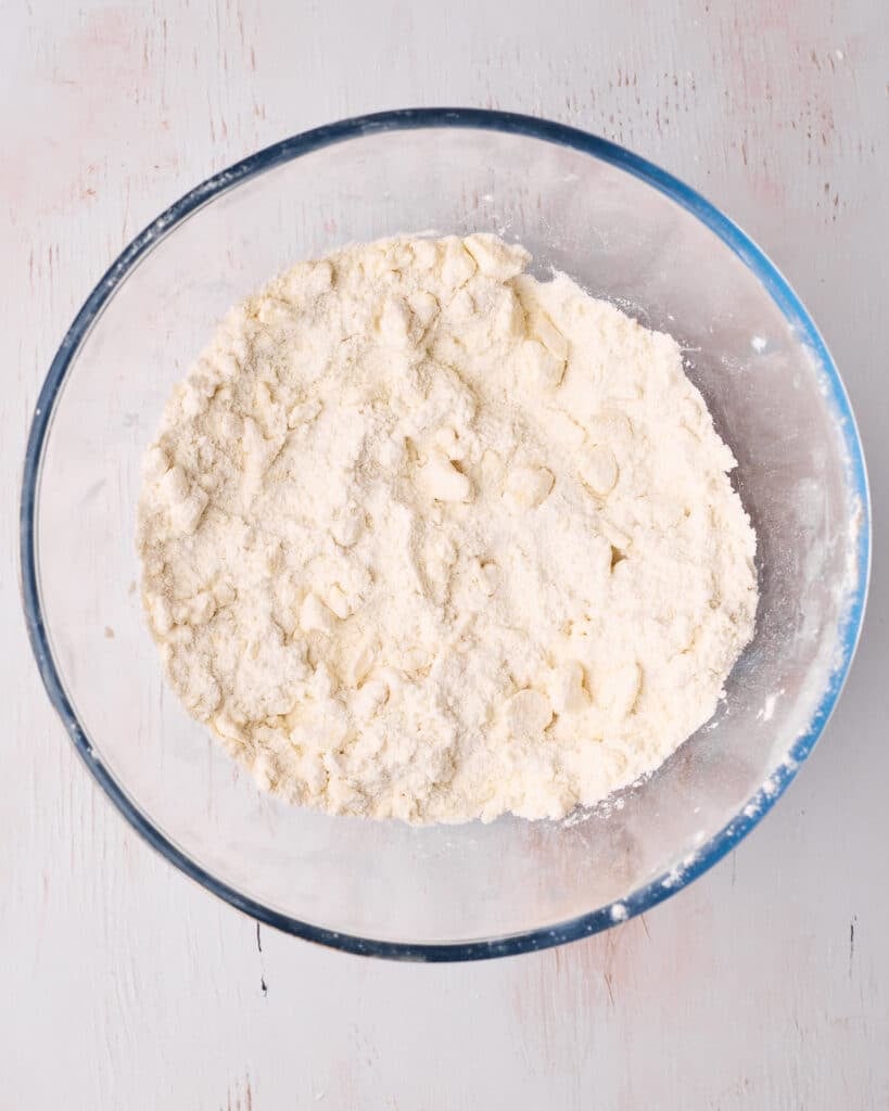 Flour, sugar, salt, and baking powder in a large bowl, mixed in with cold butter to create pea-sized lumps.