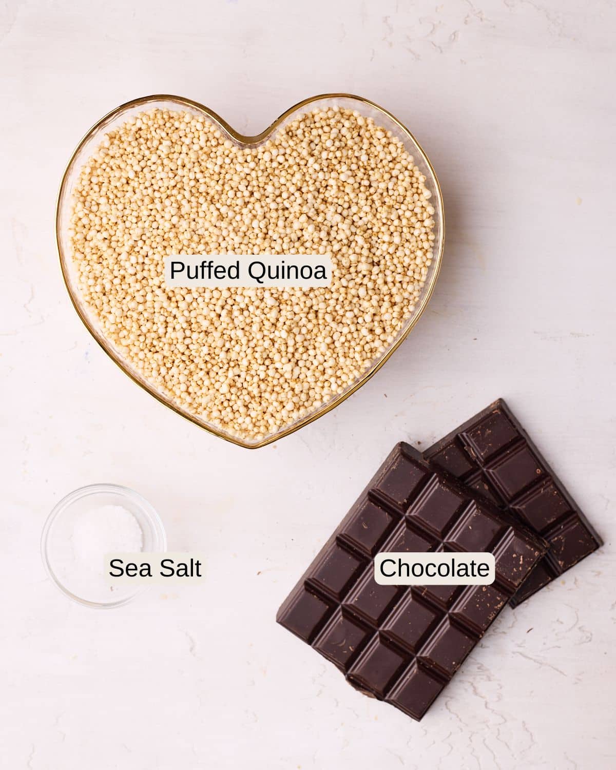 Labelled ingredients for chocolate quinoa crisps, including puffed quinoa, chocolate, and sea salt.