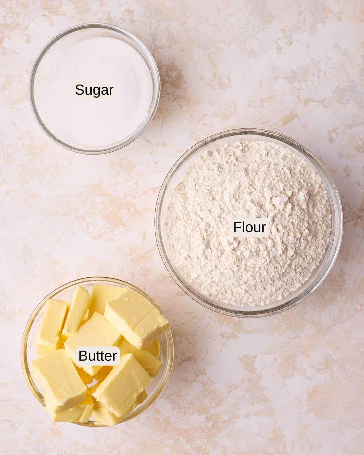 Labelled ingredients for shortbread cookies, including sugar, flour, and butter.