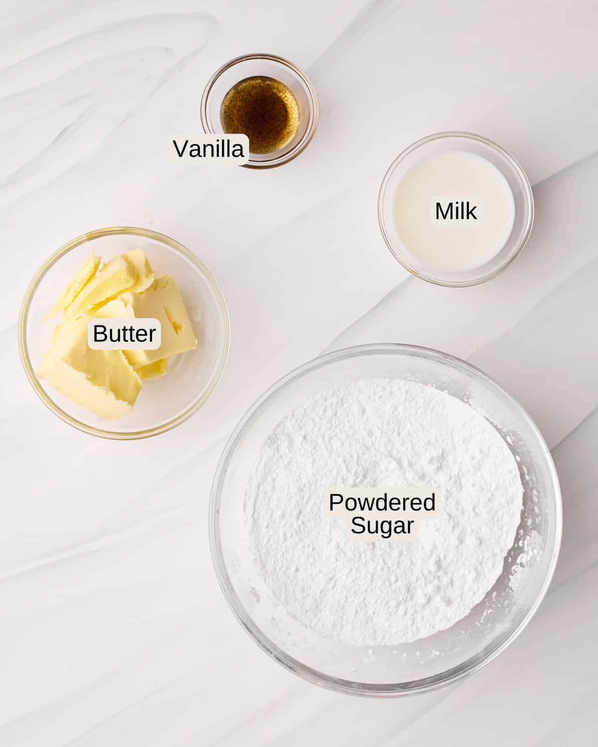 Ingredients to make powdered sugar glaze, including powdered sugar, butter, milk, and vanilla bean paste.