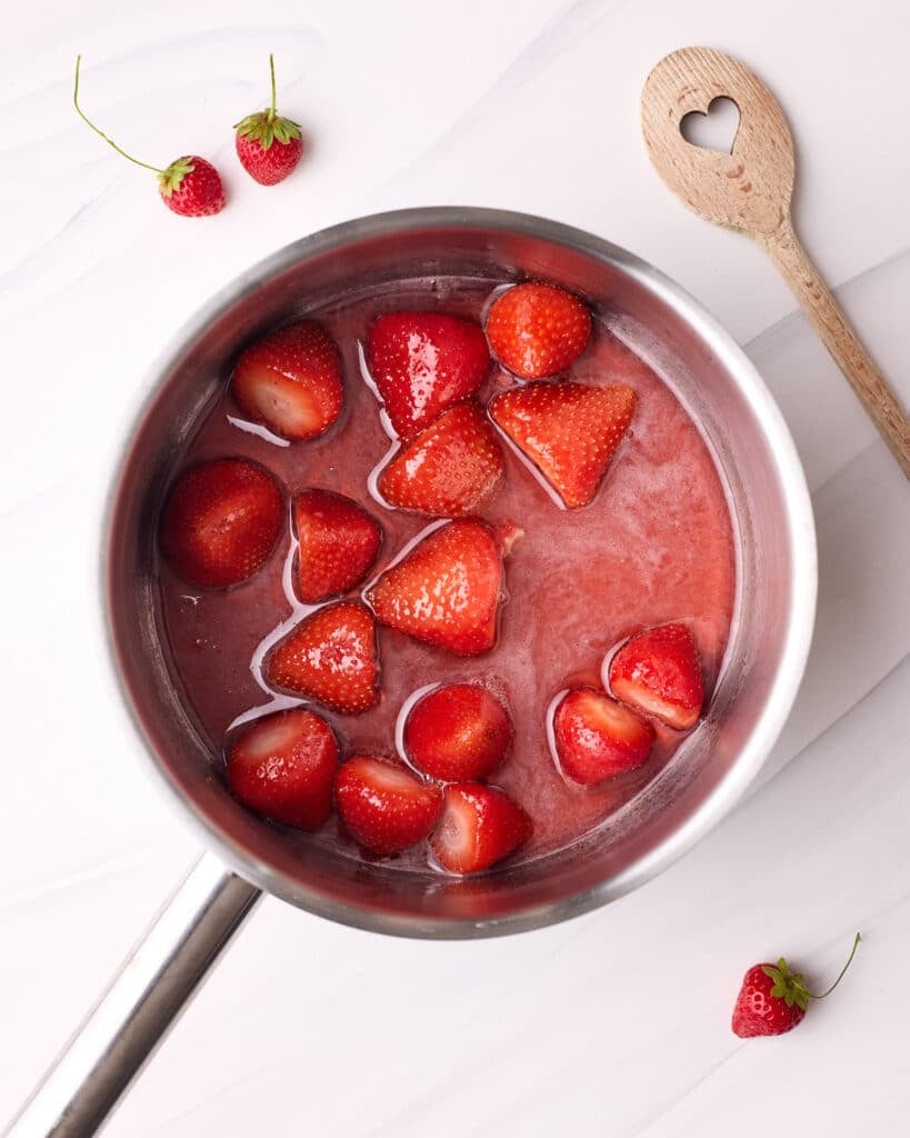 Hulled strawberries in a saucepan with sugar.