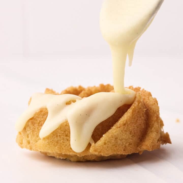 Vanilla glaze being drizzled over a mini bundt cake.