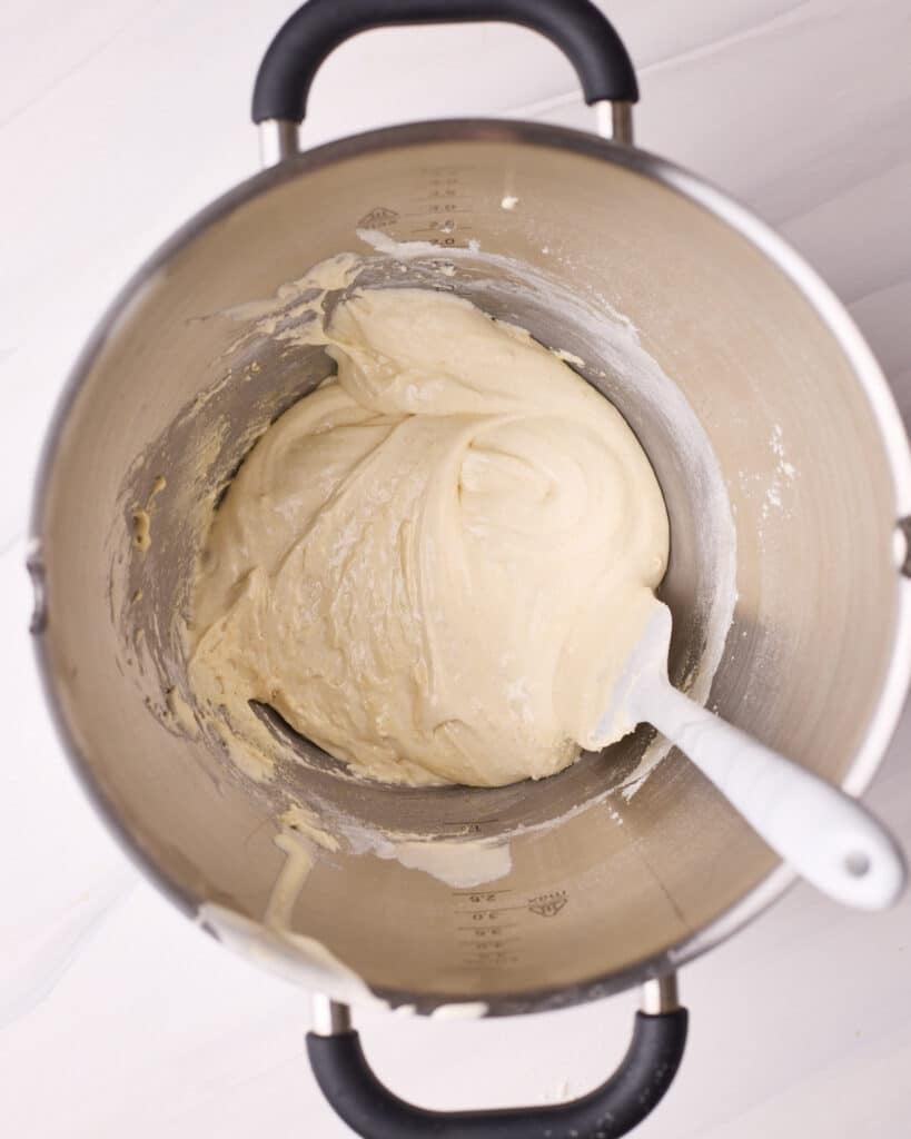 Folding flour and dry ingredients into whipped eggs and sugar to make a sponge cake.