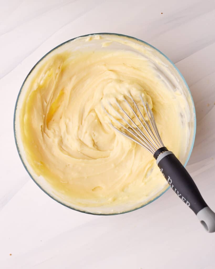 Chilled pastry cream being whisked gently to bring back the smooth texture.