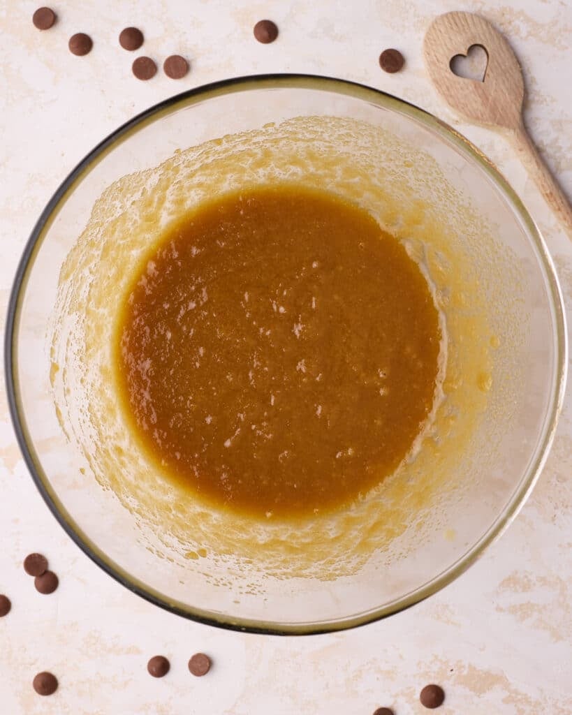 White and brown sugar mixed into the melted butter in a large bowl.