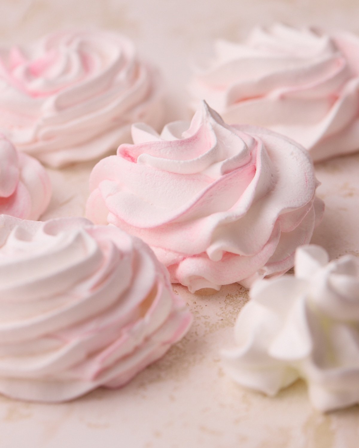 Close up of pink meringue cookies shaped as roses.