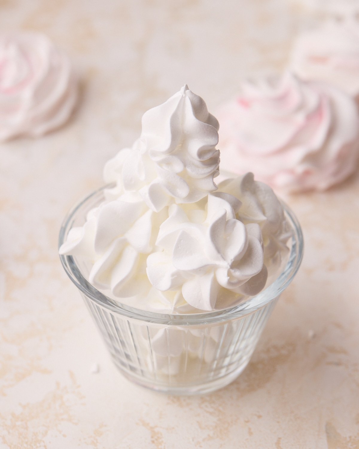 Tufts of white meringue cookies in a small glass.