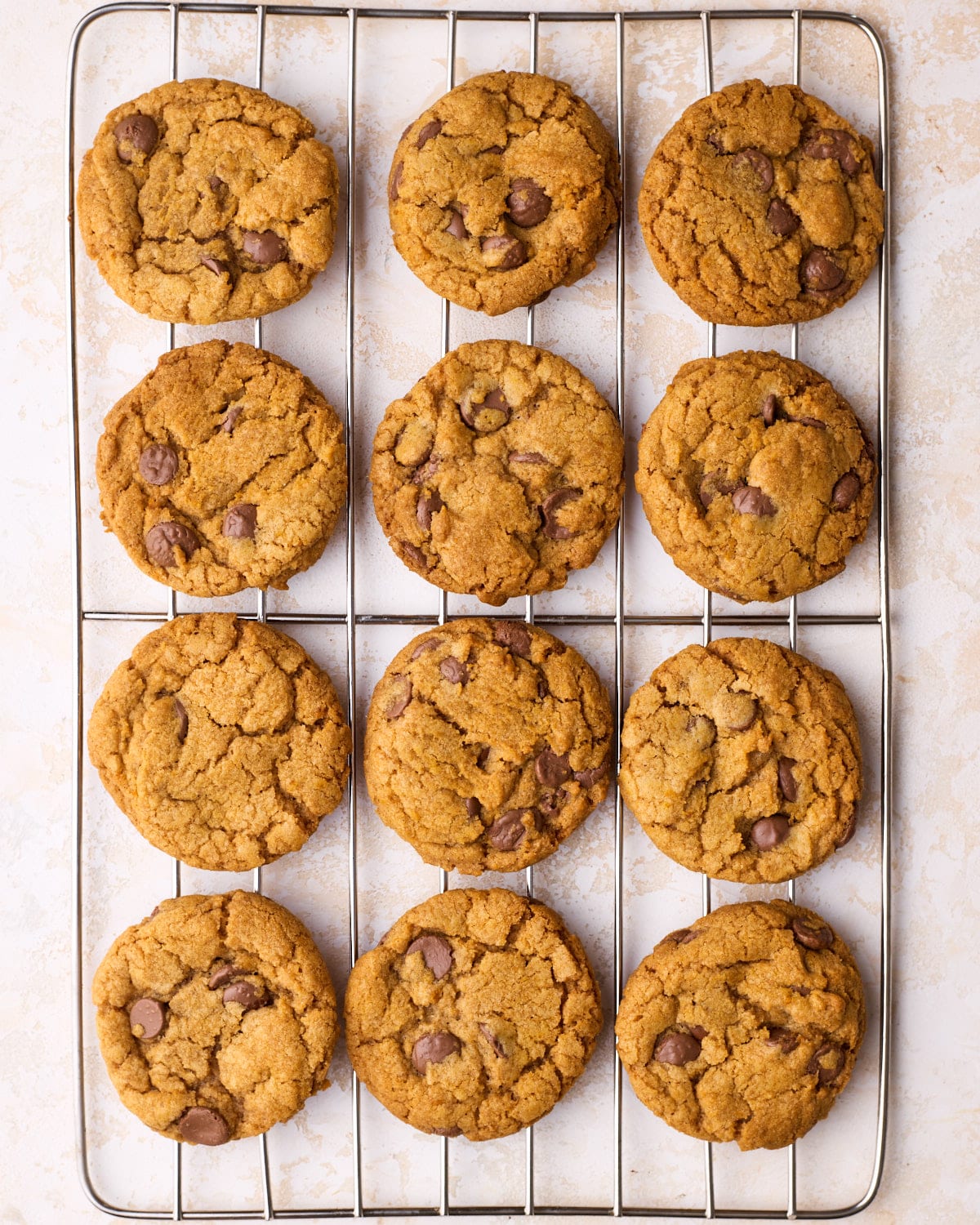Freshly baked pumpkin chocolate chip cookies cooling on a wire rack.