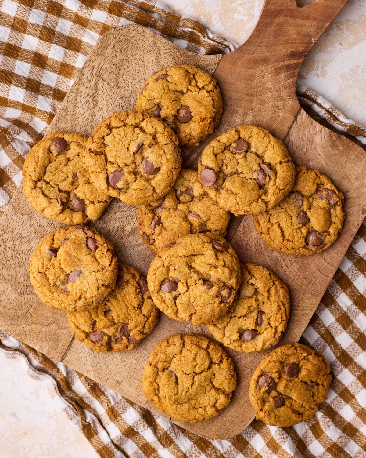 Overhead shot of pumpkin chocolate chip cookies on a wooden board.