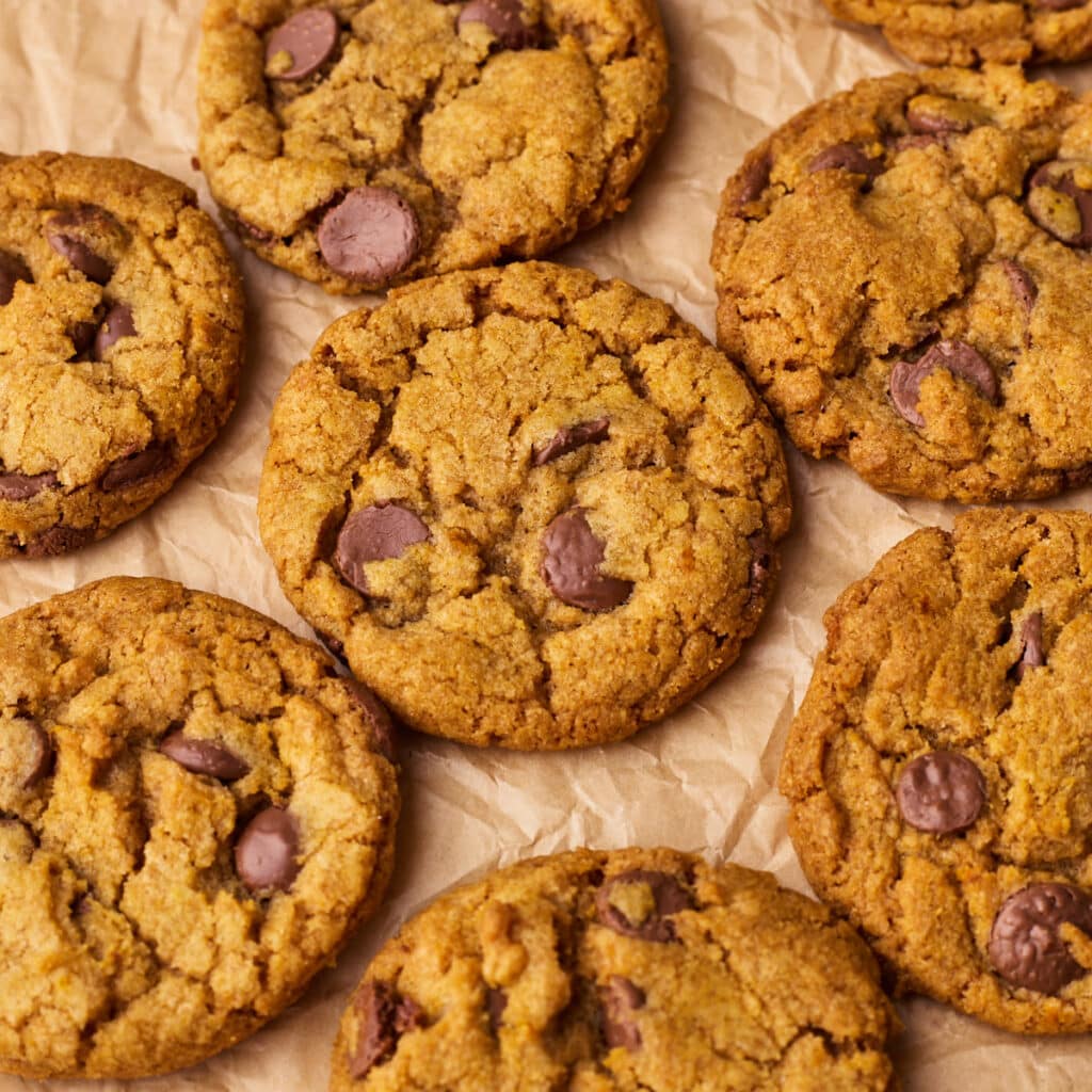 Close up of pumpkin chocolate chip cookies from above on a piece of parchment paper.