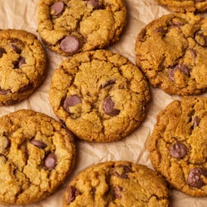 Close up of pumpkin chocolate chip cookies from above on a piece of parchment paper.