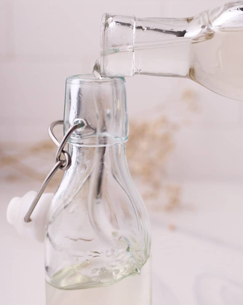 Simple syrup being decanted into a glass bottle.