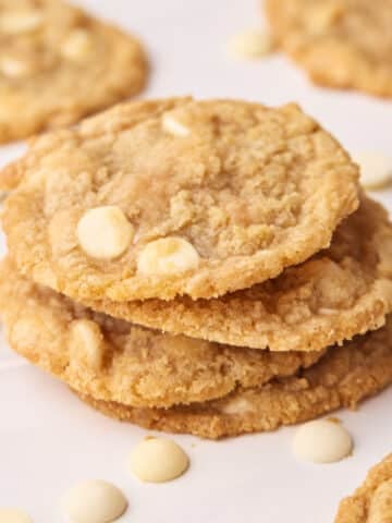 Tower of white chocolate chip cookies stacked on top of each other.