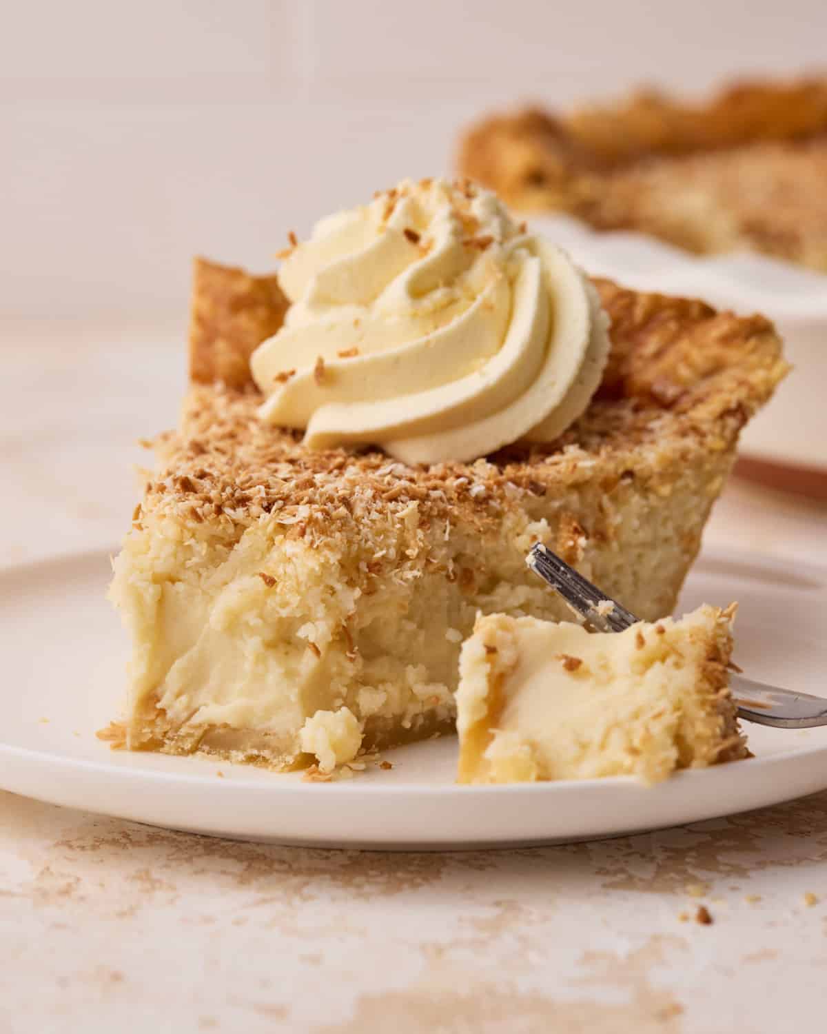 Close up of a slice of coconut custard pie being scooped with a fork.
